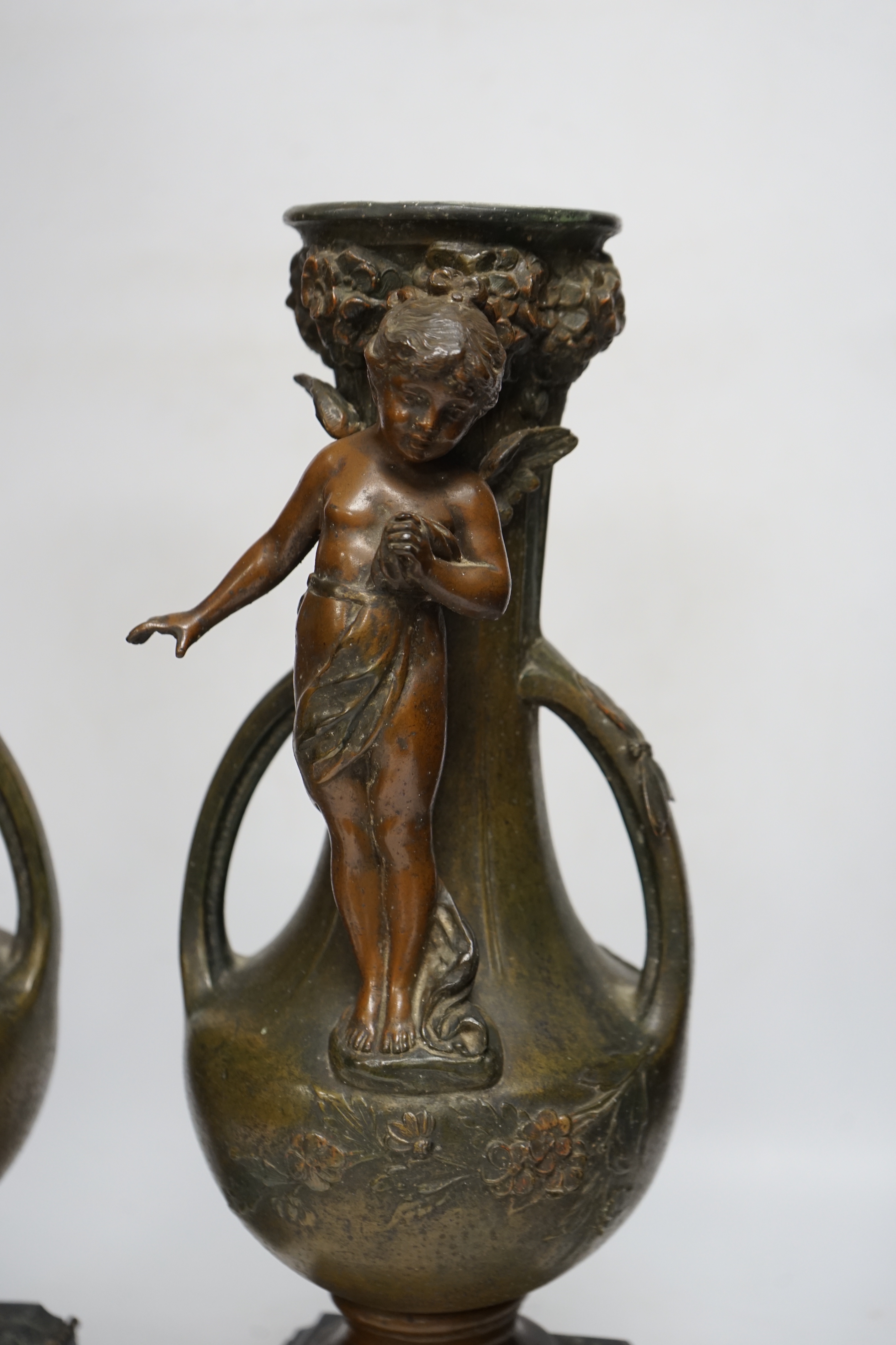 After Hippolyte François-Moreau (1832-1927), a pair of bronzed spelter cherubic vases on marble bases, 42cm